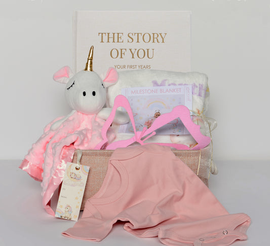 Introducing our Milestone Moments Gift Basket - the perfect way to celebrate every precious moment in a baby's journey. Whether you're welcoming a new addition to the family or attending a baby shower, this thoughtfully curated gift basket is sure to bring joy and create lasting memories.  Inside this beautifully designed magical unicorn and rainbow gift basket, you'll find a selection of carefully chosen items that will make every milestone extra special: